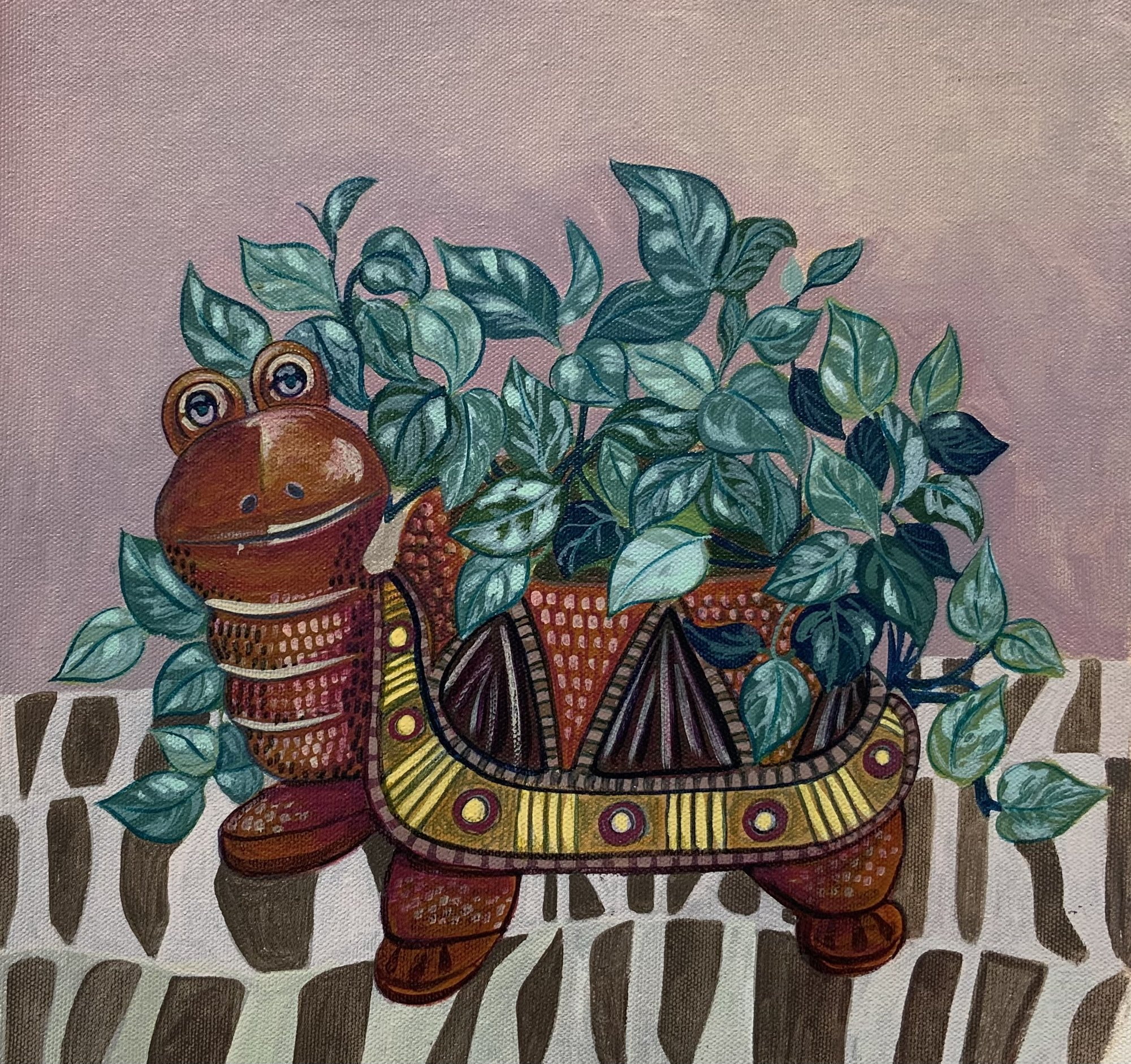 Patterned turtle-shaped planter filled with trailing green leaves.